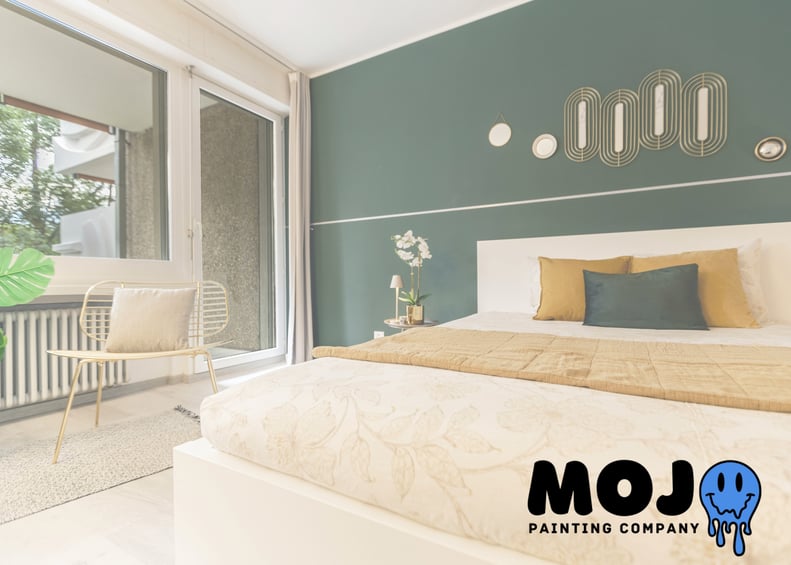 Deep green matte accent wall in contemporary bedroom, professionally painted by Mojo Painting Company to elevate home value