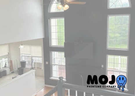 Professional black accent wall in a living room with large windows, interior painting services by Mojo Painting Company in Phoenixville PA